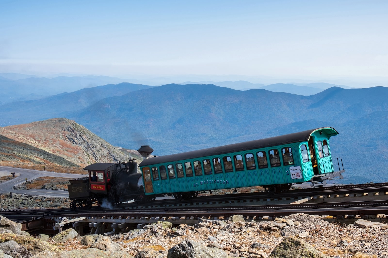 Climbing up the mountain on the Mt. Washington Cog Railway. Caboose pushing passenger car up the tracks.