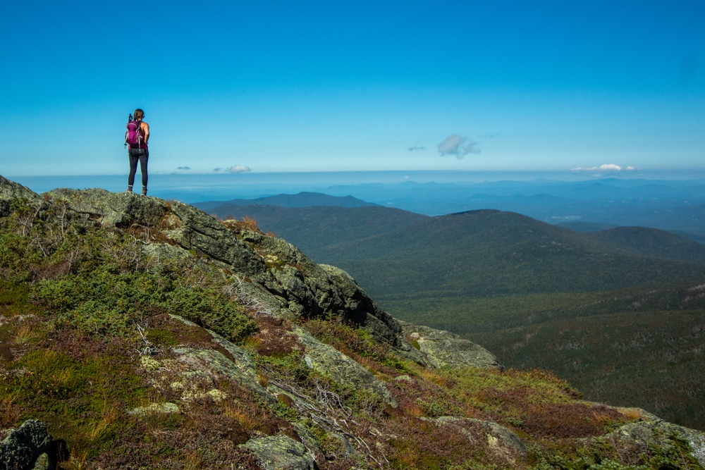 Woman standing at the top of Mount Washington after the grueling hike