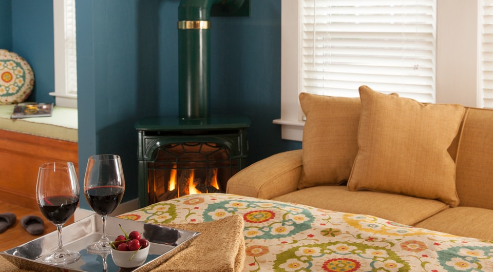 Cozy scene by the fire with wine, in our guest room at our White Mountains Bed and Breakfast, perfect after enjoying some of the best cross-country skiing in New Hampshire.