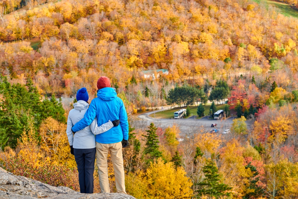 Couple enjoying the vibrant fall foliage on the Artists Bluff Trail in New Hampshire