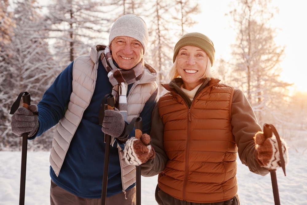 An older couple enjoying cross-country skiing, one of the top-rated things to do in the White Mountains in winter near our cozy New Hampshire Inn