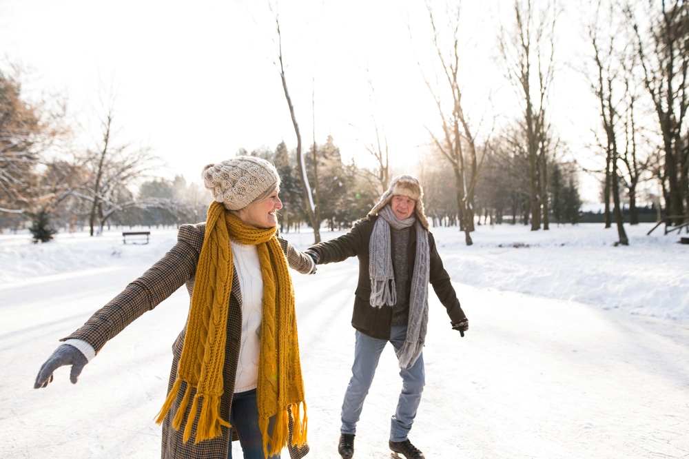 A senior couple ice skates together during their romantic getaway in New Hampshire.