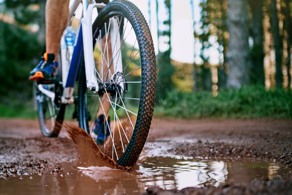 Hit the Trails at Waterville Valley Ski Resort 4 mountain biker going through the mud on trails like those at the Waterville Valley Ski REsort