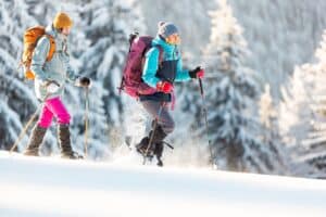 Two women snowshoeing in the mountains, at places like Great glen Trails in New Hampshire