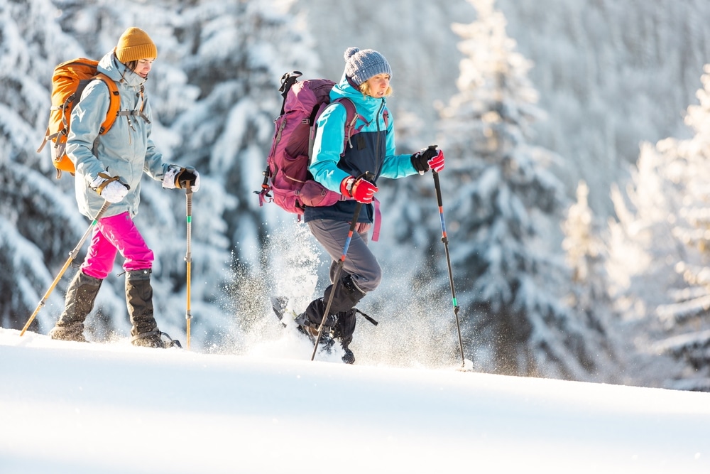 Two women snowshoeing in the mountains, at places like Great glen Trails in New Hampshire